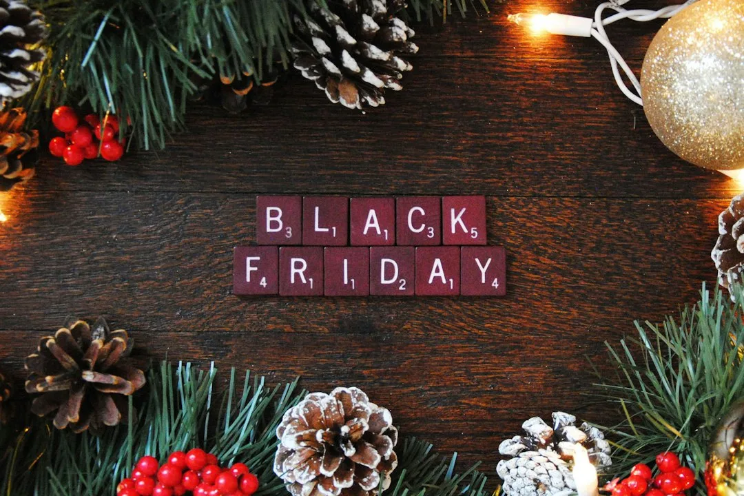 Black Friday spelled in letter tiles among pine branches and Christmas decorations