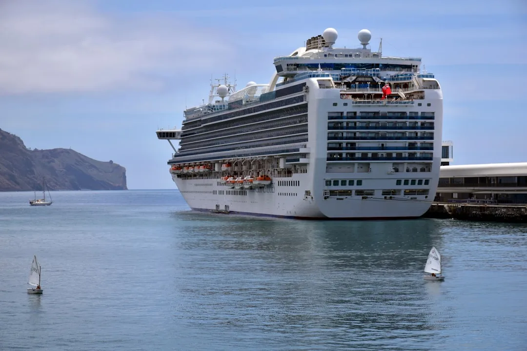 white and blue ship on sea under blue sky and white clouds during daytime