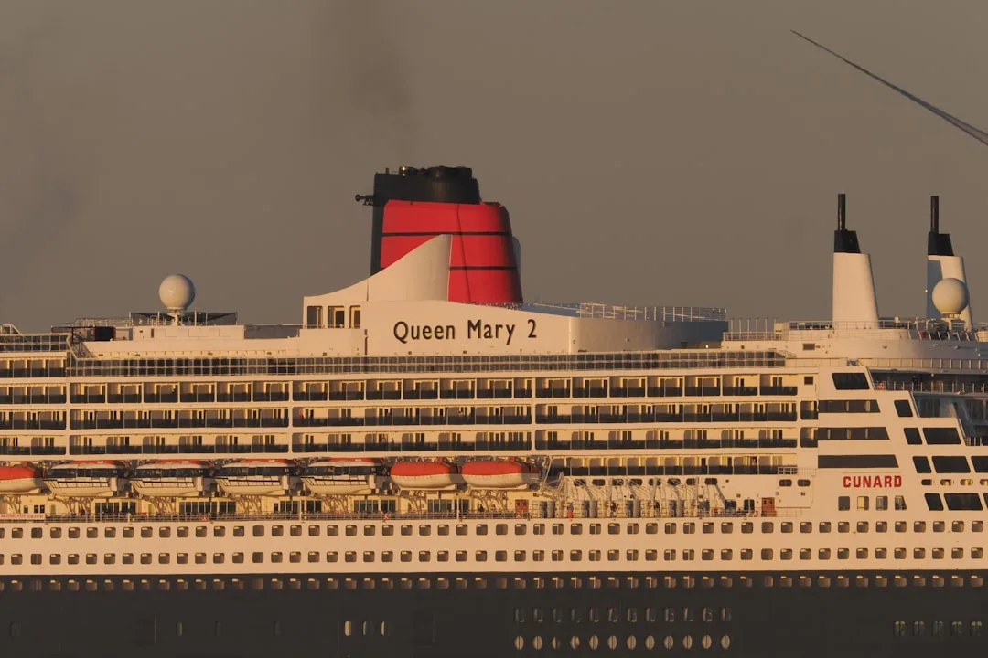 sailing white and blue cruise ship under cloudy sky