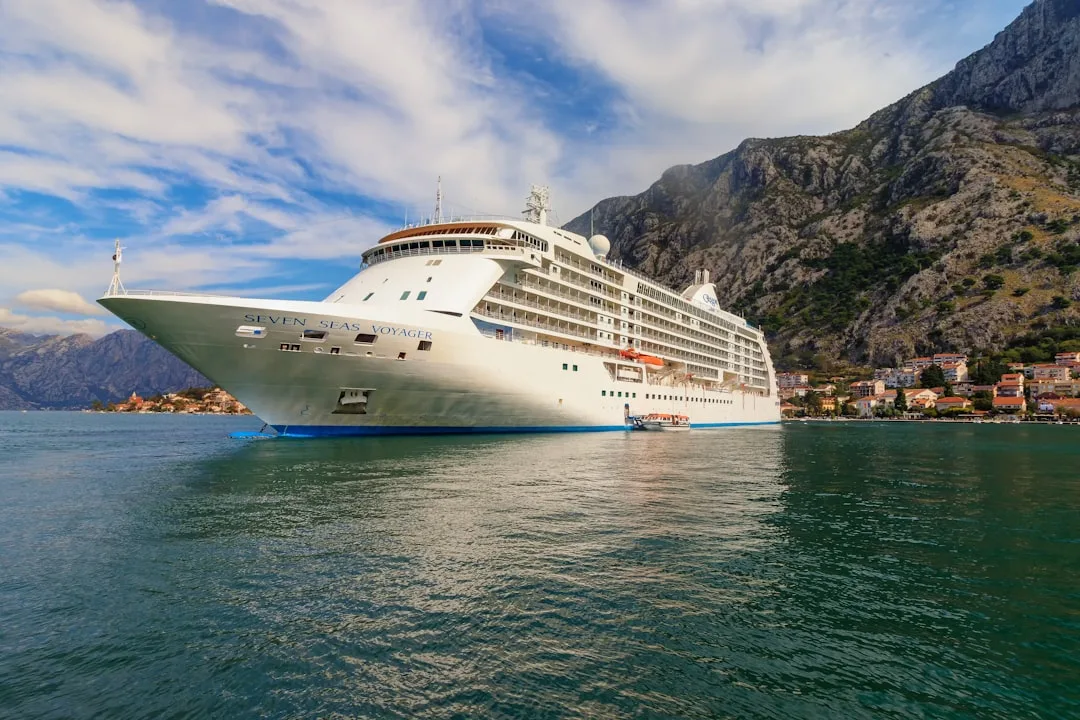 A cruise ship in the water with mountains in the background