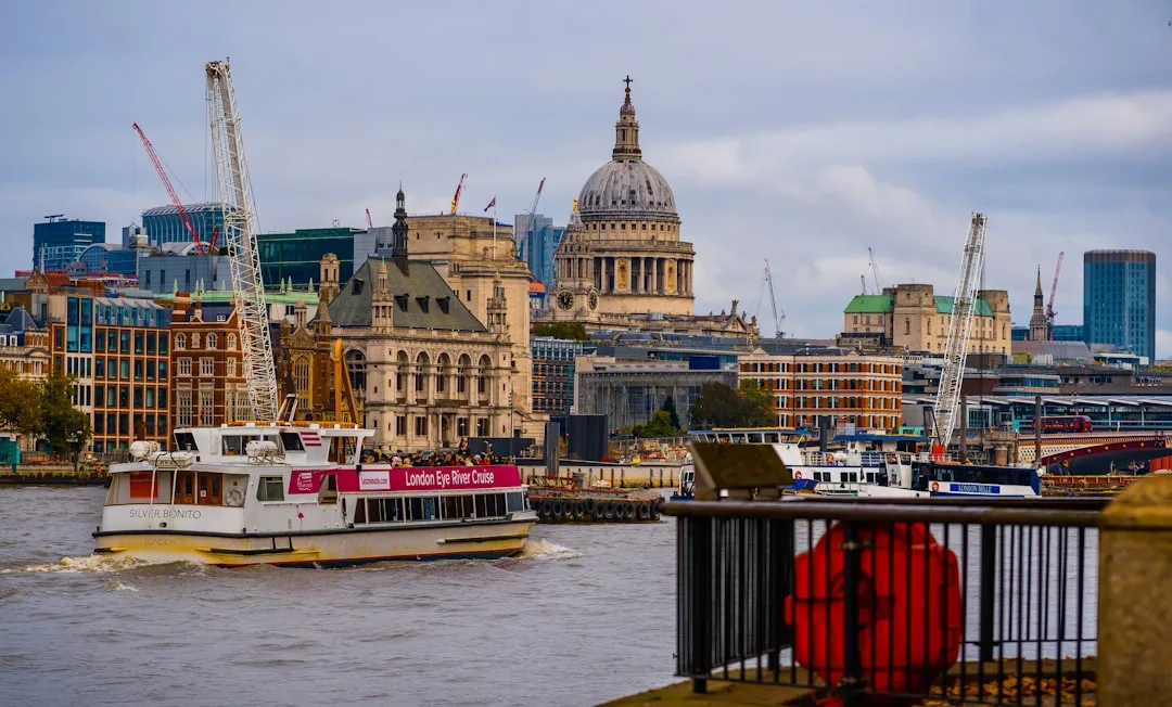 A boat traveling down a river next to tall buildings