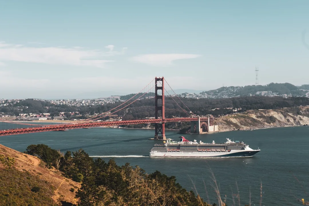 a cruise ship passing under the golden gate bridge